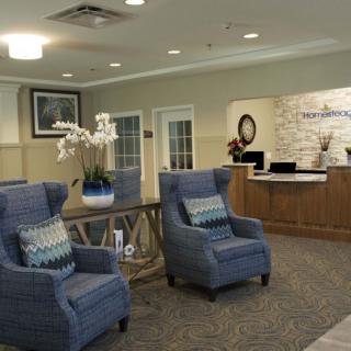 A cozy lobby with blue armchairs and a reception desk.