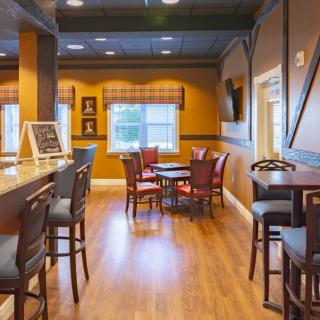 A cozy bar and restaurant interior with wooden floors and ample seating.