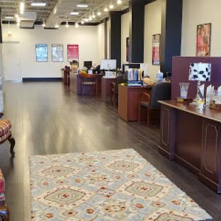 A modern office interior featuring multiple workstations and a decorative rug.