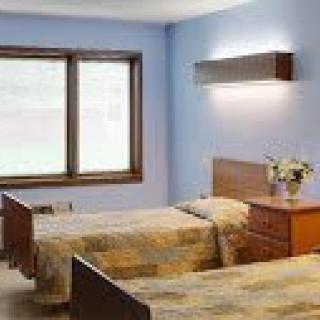 A cozy bedroom with twin beds and a large window.