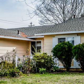 A suburban house with a well-maintained yard and shrubs.