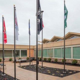 A courtyard featuring several flags in front of a modern building.