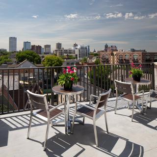 A rooftop terrace with outdoor seating offering a view of the city skyline.