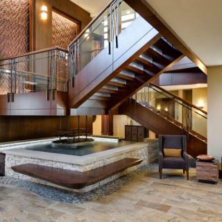 A modern lobby featuring a stylish wooden staircase and seating area.