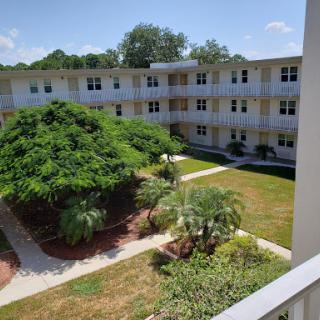 A view of an apartment complex with a lush courtyard and multiple levels.