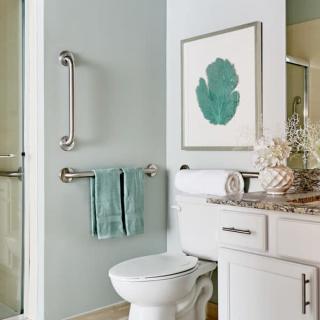 A modern bathroom featuring a toilet, towels, and decorative artwork on the wall.