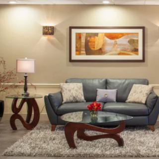 A modern living room featuring a sleek grey sofa, artistic coffee table, and abstract wall art.
