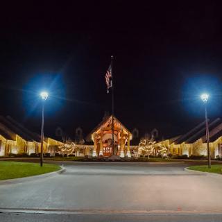 An illuminated building with a flag at night, showcasing a peaceful landscape.
