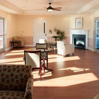 A spacious living room with modern furniture, a fireplace, and bright natural lighting.
