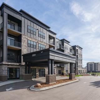 A modern multi-story apartment building with large windows and balconies, showcasing contemporary urban residential design.