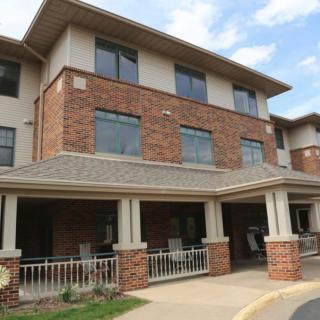 A multi-story residential building with a brick exterior and a covered porch.