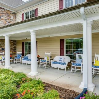A welcoming front porch with rocking chairs and white columns.