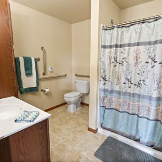 A clean and organized bathroom featuring a shower, toilet, and sink.