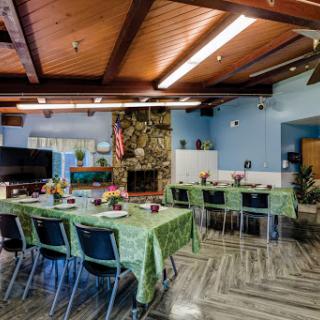 A cozy dining area set up for a gathering, featuring green tablecloths and decorative elements.