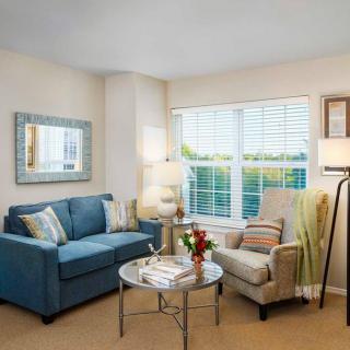 A cozy living room with a blue sofa and armchair, complemented by a coffee table and decorative items.