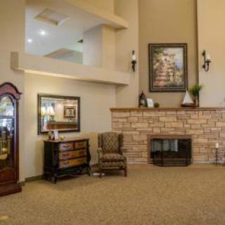 A cozy living room featuring a brick fireplace, grandfather clock, and comfortable seating.