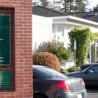 A funeral home with cars parked in front of the building.