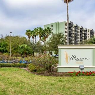 A hotel with a prominent sign and well-maintained landscaping featuring palm trees.