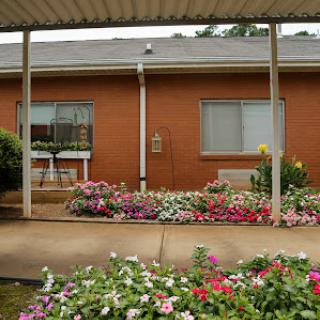 A beautiful garden with colorful flowers in front of a residential building.