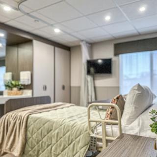 A modern hospital room designed for patient comfort with cozy bedding and contemporary furnishings.