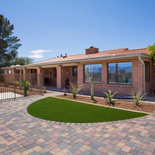 Modern brick house with a landscaped yard and paved driveway.