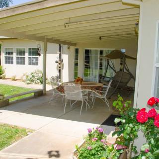 A cozy backyard patio with seating area and blooming roses.