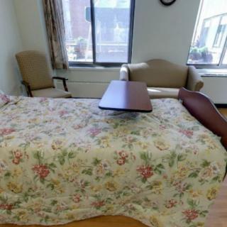 A cozy bedroom with floral bedding and comfortable seating.