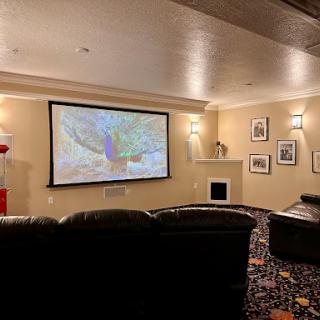 A cozy home theater setup featuring a projector screen and comfortable seating.