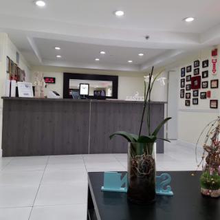 A modern reception area featuring a sleek desk and decorative plants.