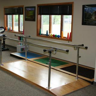 A physical therapy room featuring balancing bars for rehabilitation exercises.