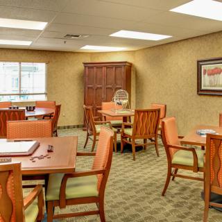 A well-lit dining room with multiple tables and chairs arranged for seating.