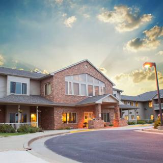A suburban residential building with a brick facade at sunset.