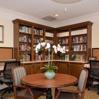 A cozy library corner with bookshelves, a round table, and chairs.