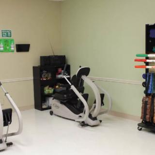 A small gym area featuring various exercise machines and equipment.