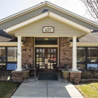 A building with a central entrance featuring columns and brick facade.