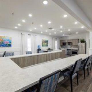 A modern kitchen and dining area with ample seating and bright lighting.
