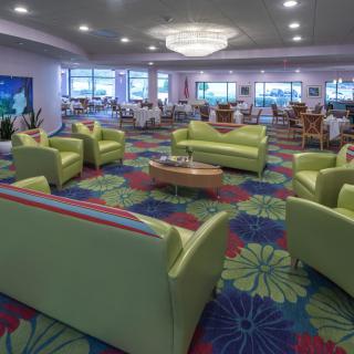 A modern lounge area with green couches and a vibrant, colorful carpet.