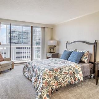 A modern and comfortable bedroom with a city view, featuring stylish decor and furniture.