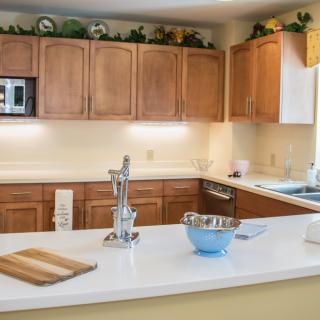 A modern kitchen with wooden cabinets and a clean white countertop.