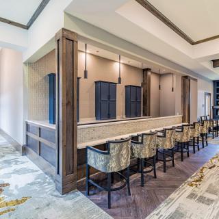 A modern bar area with a long counter and stylish seating.