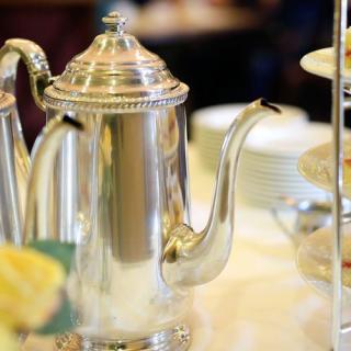 A silver teapot elegantly displayed on a dining table.
