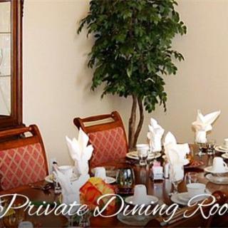 A well-set private dining room with elegant table settings and decor.
