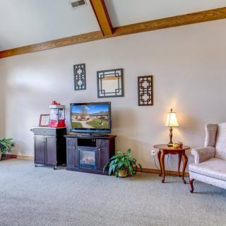 A cozy living room with a TV stand, armchair, and decorative elements.