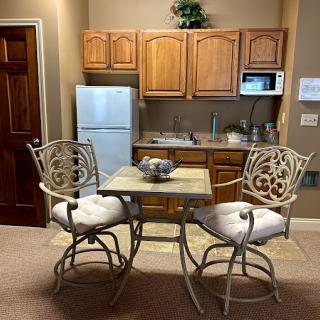 Cozy kitchen with a small dining area featuring a table and two ornate chairs.