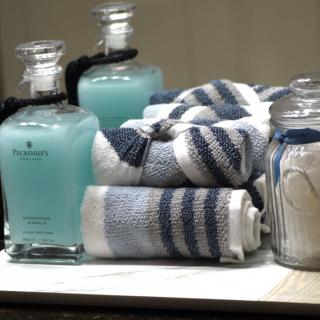 A neatly arranged set of blue-striped towels and bottles of soap adorn a bathroom counter.