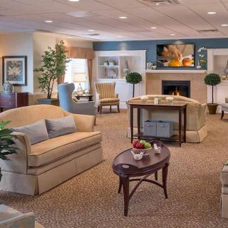A cozy and elegantly decorated living room with sofas, a coffee table, and a fireplace.