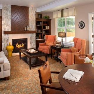 A cozy living room with a fireplace, armchairs, and elegant decor.