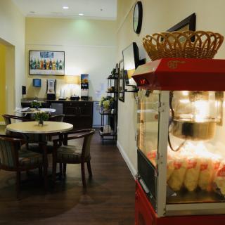 Interior view of a cozy dining area featuring a popcorn machine and wooden furniture.