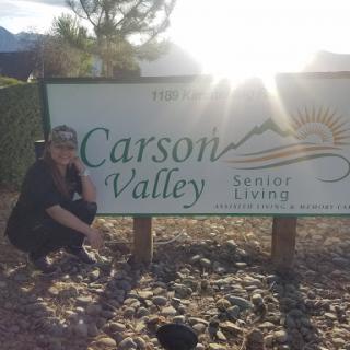 A person posing next to the Carson Valley sign, basking in the sunlight.