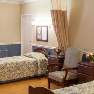 A shared hospital room with two beds and a curtain divider.